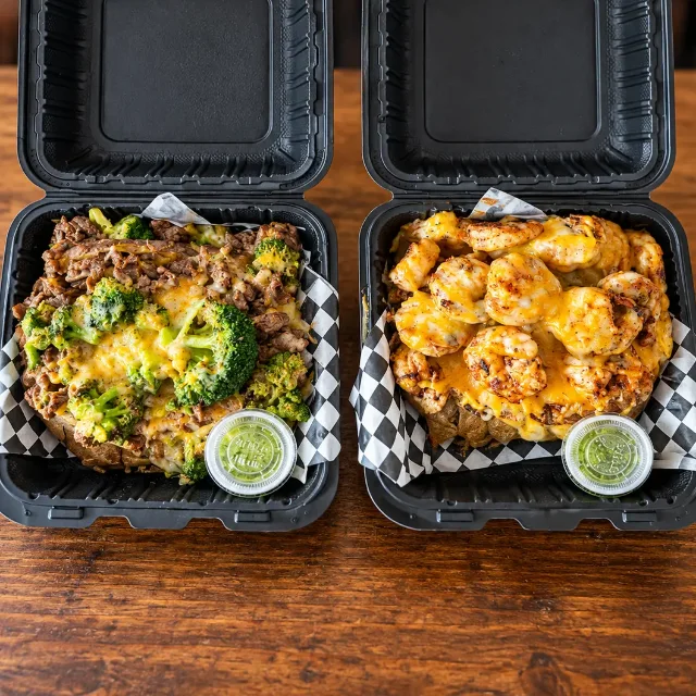 Two OverFlo Potato boxes ready for pickup: steak with broccoli and shrimp with melted cheese