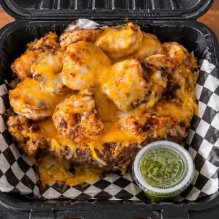 ShrimpFlo baked potato piled with seasoned shrimp and melted cheddar