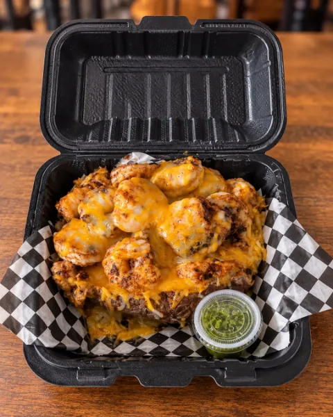 ShrimpFlo baked potato piled with seasoned shrimp and melted cheddar
